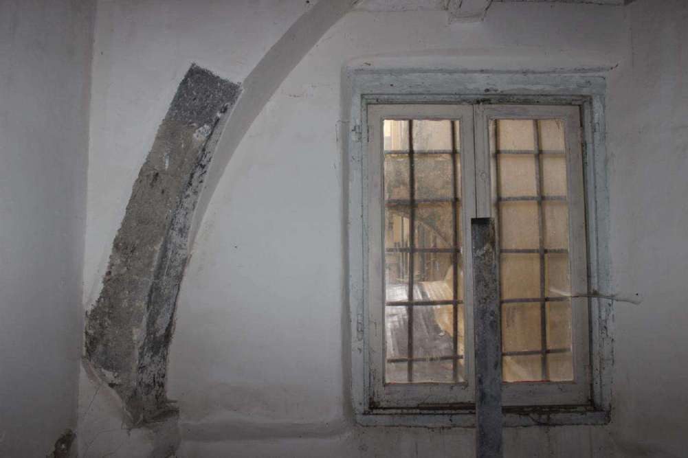 Arco a tutto sesto in pietra inglobato in una parete del primo piano
